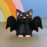 Close-up of black bat figurine with glossy eyes and tiny fangs, gothic bat decor