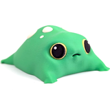 A green blob frog with a vacant expression on his face sits on a white background. He has yellow eyes and cream colored spots.