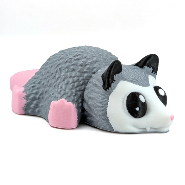 An adorable possum with a pink tail and paws sits on a white background.