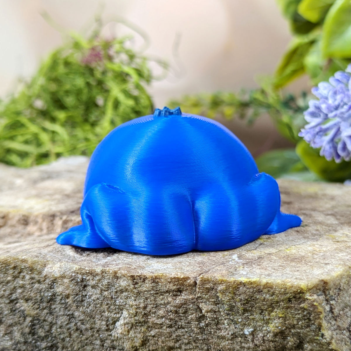 Rear view of Blueberry Frog figurine highlighting its smooth, rounded back and frog legs.