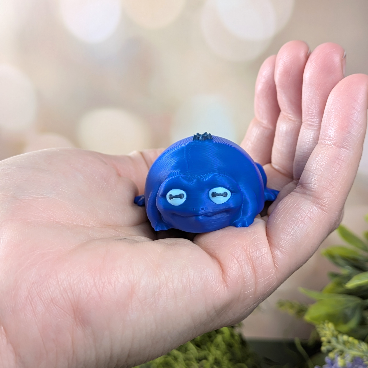 Blueberry Frog resting in the palm of a hand, showing scale and size.