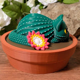 Side profile of cactus cat figurine in pot with ridged details visible.