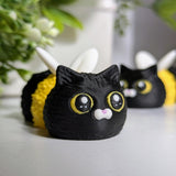 Close-up of the Cat Bee’s wide yellow eyes and perky ears, with another bee-cat buddy blurred in the background.