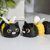 Two Cat Bees sit side by side, one facing forward and the other glancing to the side like they’re plotting something sweet and fuzzy.