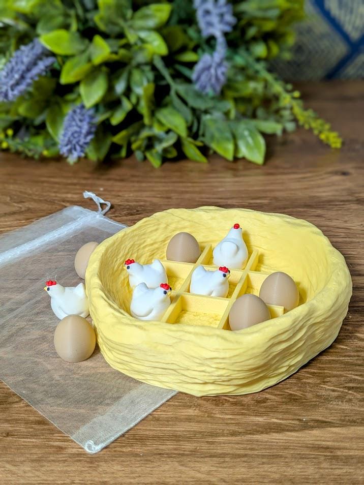 Chicken and egg tic tac toe set arranged inside a nest-style board, surrounded by greenery and flowers.