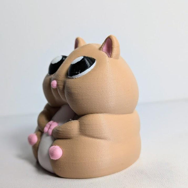 Three-quarter angle of a chubby hamster figurine, showing its little pink feet and big glossy eyes.
