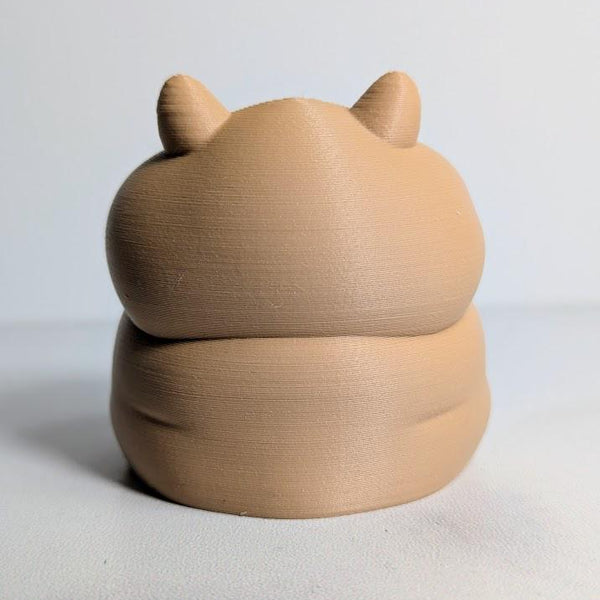 Rear view of a plump hamster figurine with small ears and a rounded back.