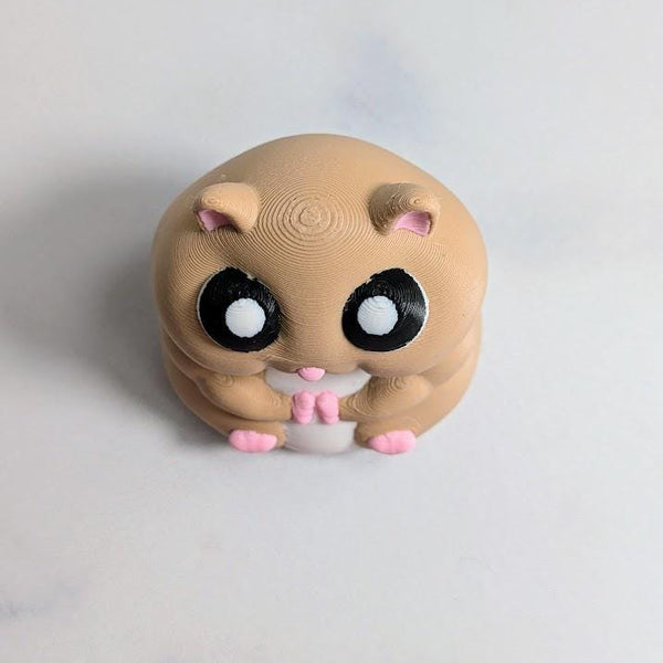 Front view of a round hamster figurine with big eyes and tiny pink feet