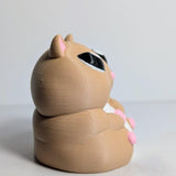 Side profile of a chunky hamster figurine showing its soft curves and tiny hands