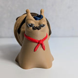 Front view of Le Escargôutier™, the croissant snail with an impeccably curled mustache, tiny snarl, and red neckerchief—looking extremely guilty of pastry crimes.