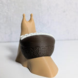 Rear view of a cupcake snail showing off its chocolate cupcake shell with white frosting peeking over the edge.