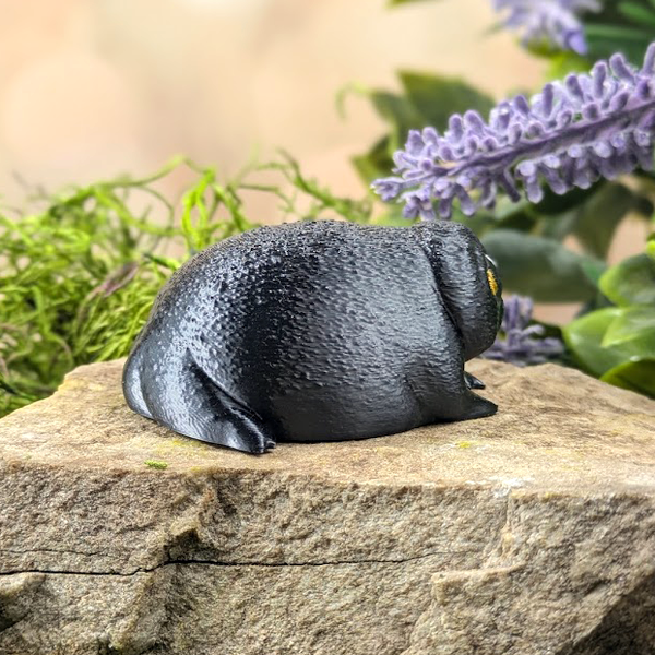 Right side view of the figurine showing its curved form, droopy pose, and sad vibe.