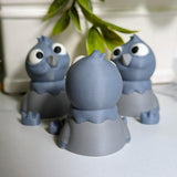 Rear view of a derpy pigeon figurine showing off their rounded back and tiny tail beneath hanging greenery.