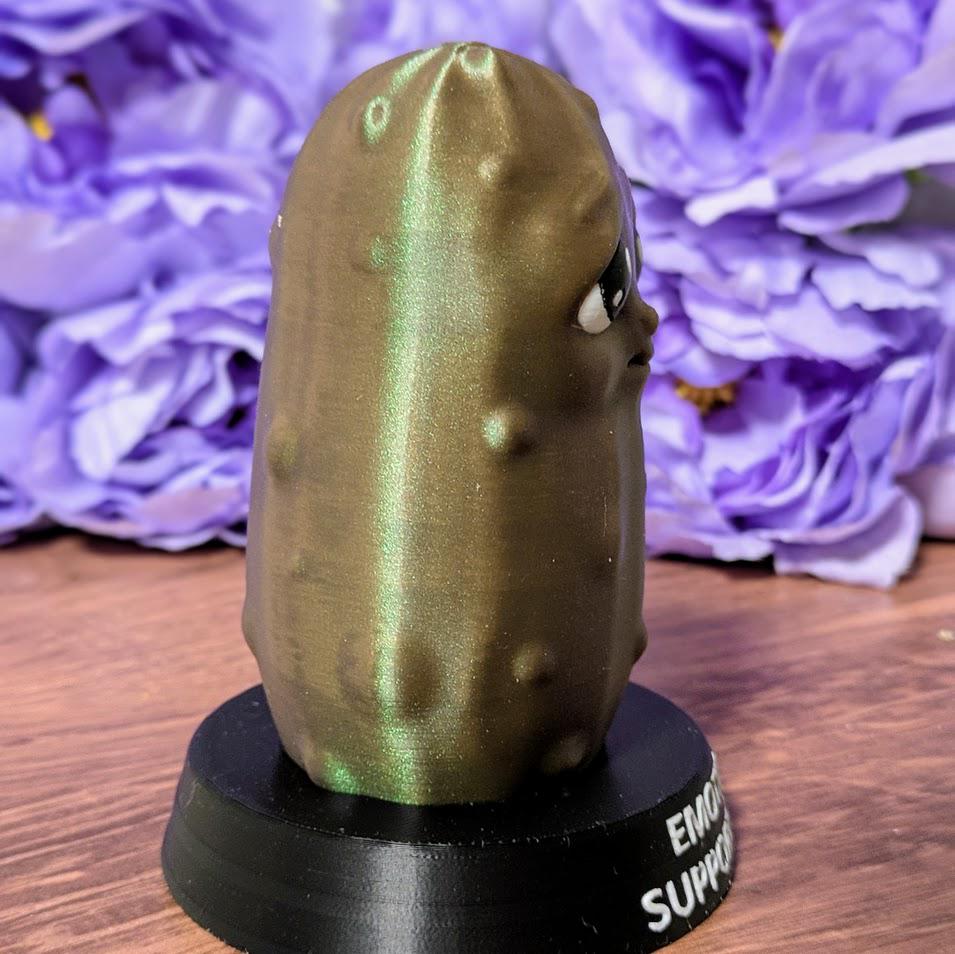 Side angle of Emotional Support Pickle on black base with textured surface and soft lighting.