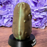 Side angle of Emotional Support Pickle on black base with textured surface and soft lighting.