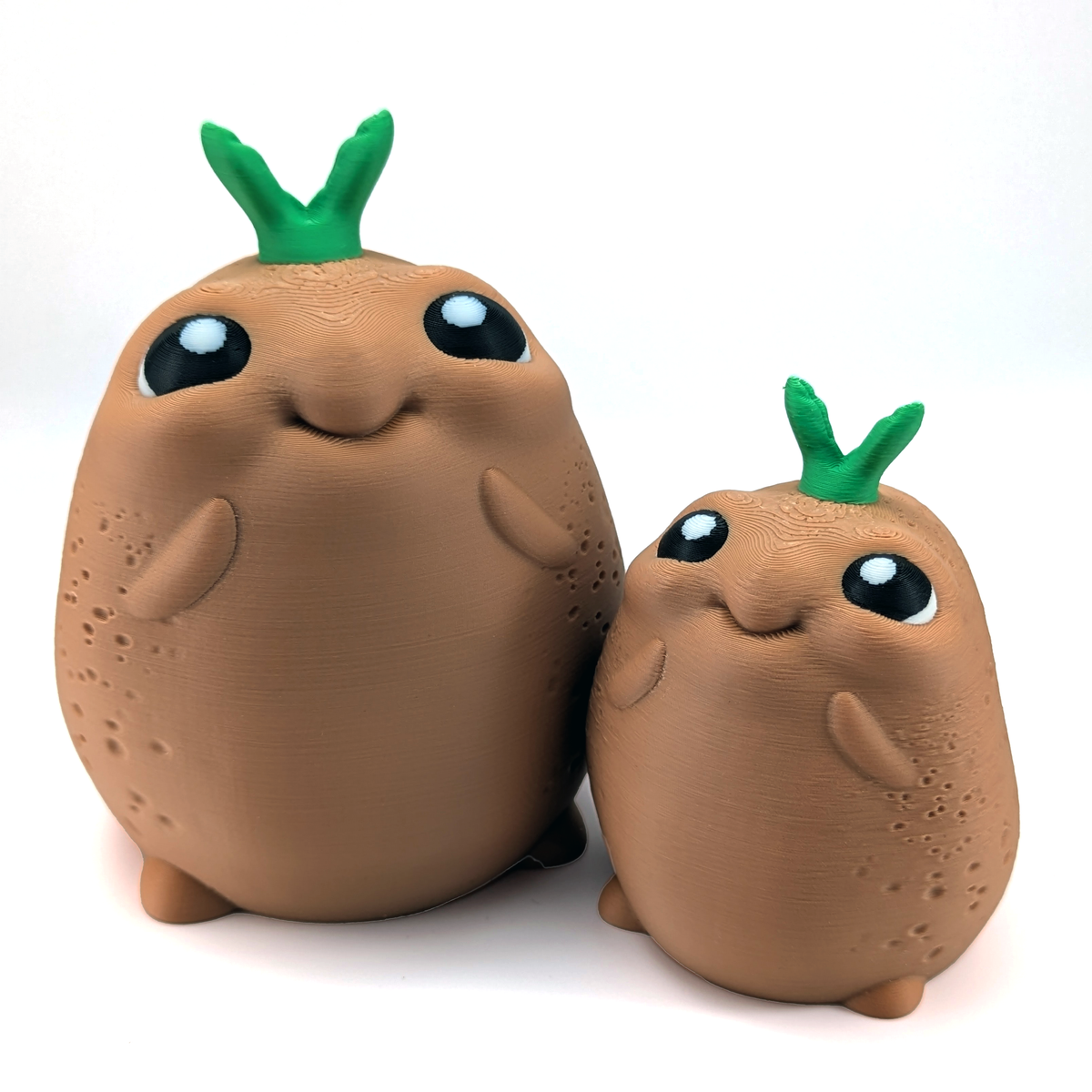 Two very cute and happy potatoes with green sprouts on their head sit on a white background.