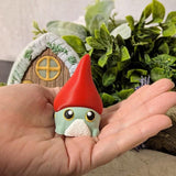 Frog gnome goblin in a large red hat, sitting in a hand to show scale.