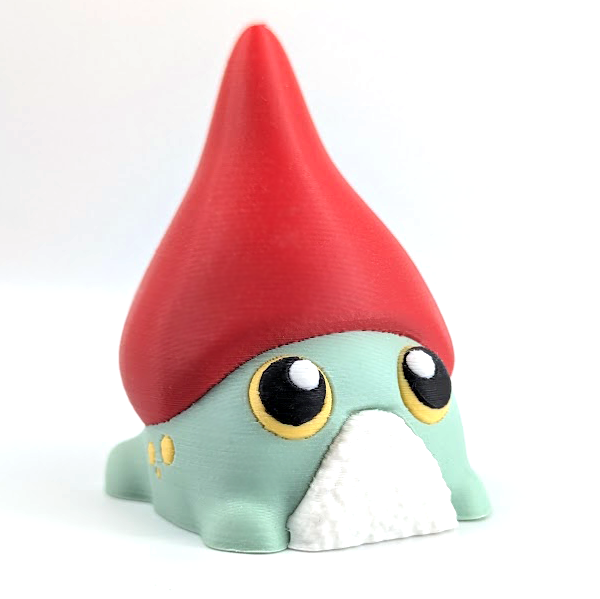 An adorable frog with huge yellow eyes, a textured white beard, and a tall red gnome hat sits on a white background.