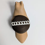 Overhead view of a Hostess-inspired cupcake snail with a tan body and chocolate-frosted shell featuring a white icing swirl.