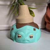 A front-facing mint chocolate chip frog with an upside-down cone hat and the energy of someone who knows they’re adorable.