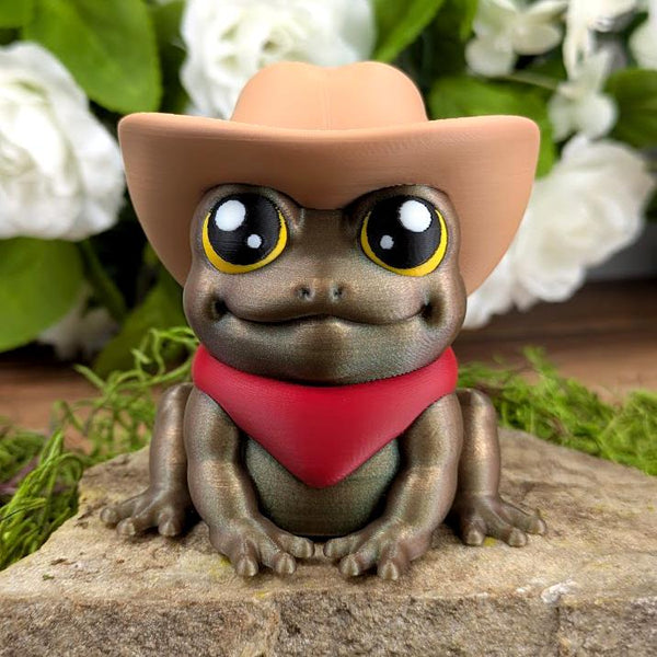Front view of Cowboy Frog figurine wearing a tan cowboy hat and red bandana, sitting with wide eyes and a metallic green finish.
