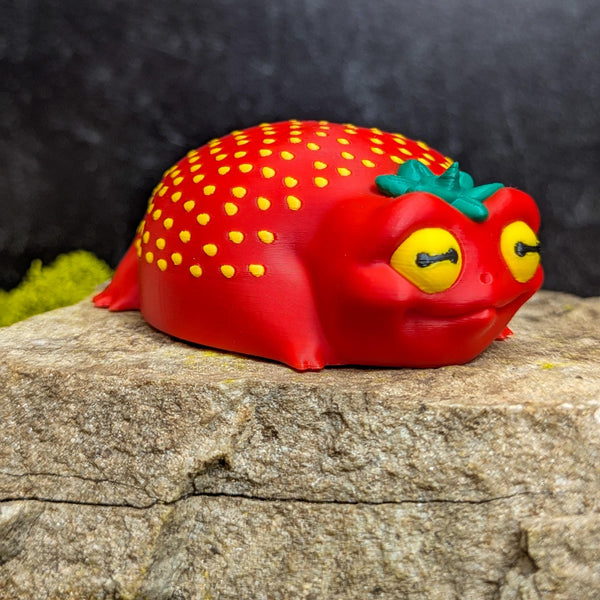 Angled shot of the strawberry frog sitting with a sleepy smirk and leafy crown