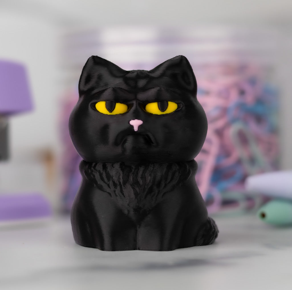 Black cat figurine with yellow eyes on a blurred background