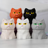 Five cat figurines in different colors with grumpy expressions on a white background.