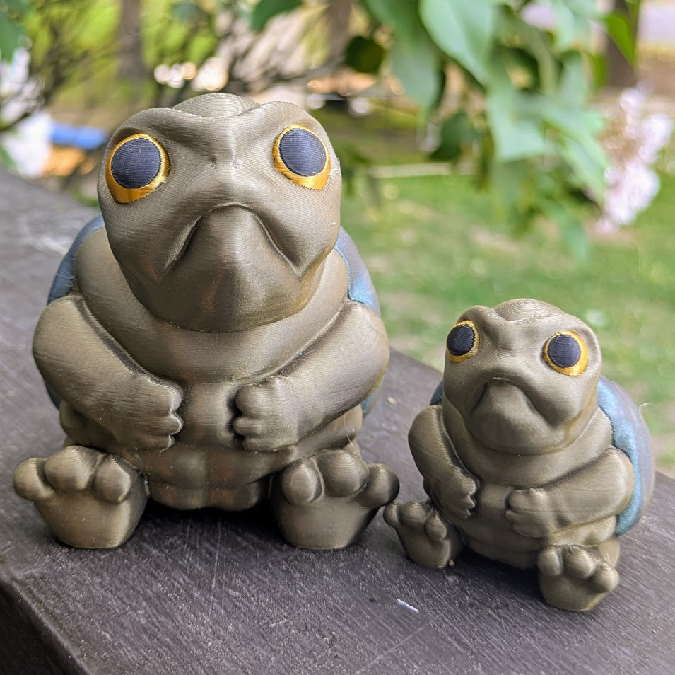 Large and small Judgmental Turtle™ figurines side-by-side for size comparison.