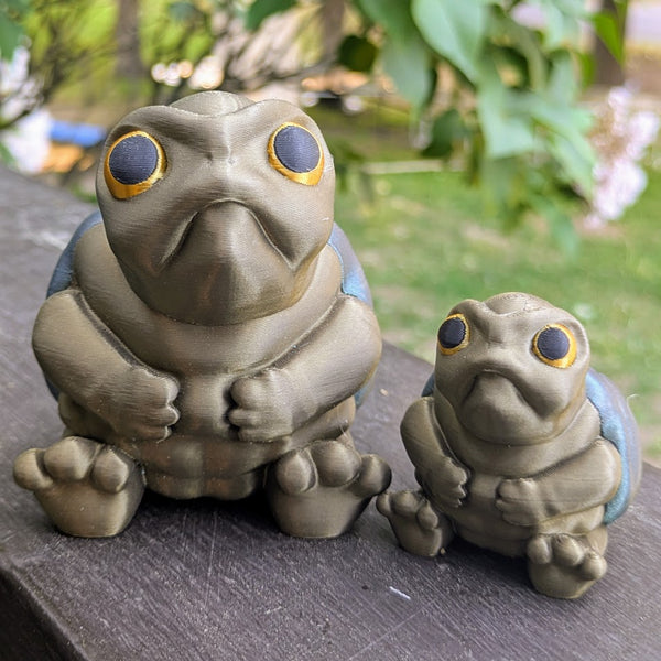 Large and small Judgmental Turtle™ figurines side-by-side for size comparison.