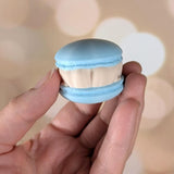 Back view of a macaron frog held in a hand, showing its rounded shape.