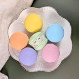 A top down view of pastel-colored macaron-shaped frogs on a decorative plate.