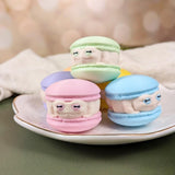 All six macaron frogs arranged in a white dish like colorful desserts.