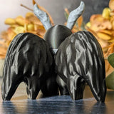 Back view of Mothman showing detailed wings and curled antennae, framed by golden fall foliage.