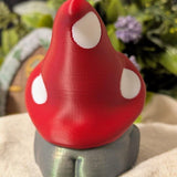 Back view of mushroom hat frog showing curved red cap with white spots and subtle shimmer on the body.