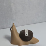 15-second video of a chubby cupcake snail with frosting swirls on his cupcake shell, rotating to show off its sweet, slightly chaotic charm.