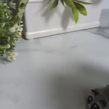 A raccoon-shaped blob figurine waddles offscreen in a short video clip, its tiny tail and ears visible from behind.