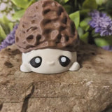 Video clip showing a rotating view of a mushroom goblin figurine with a textured morel cap and wide eyes.