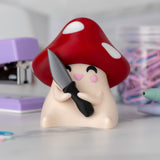 Mushroom-shaped figurine with a knife on a blurred background