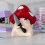 Mushroom-shaped figurine with a knife on a blurred background