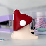 Figurine with a red mushroom cap on a blurred background