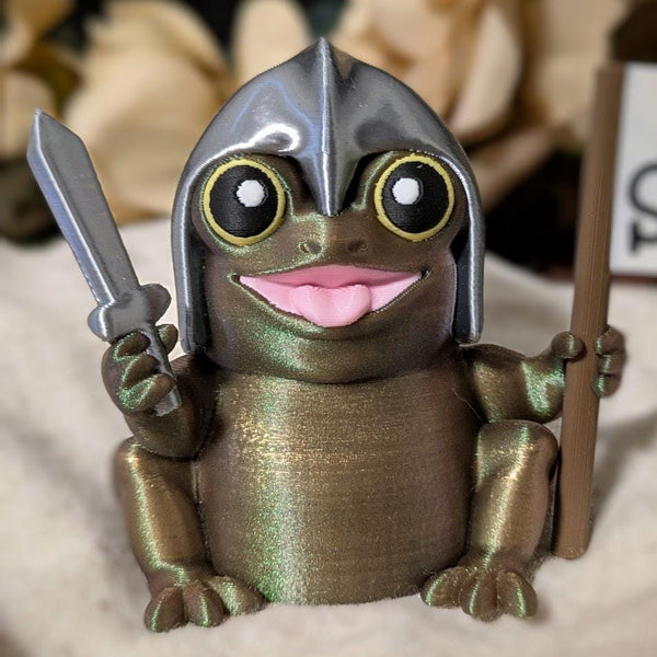 Front-facing view of Sir Glorb™ the frog knight holding a sword and a “For Snacks!” flag, smiling with a proud expression.