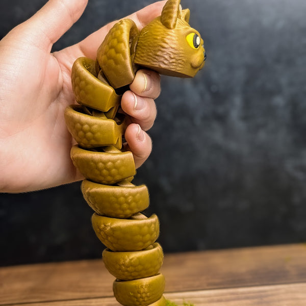 The Snat held upright in one hand, coiled downward like a spiral, showing off its poseable segments and textured body.