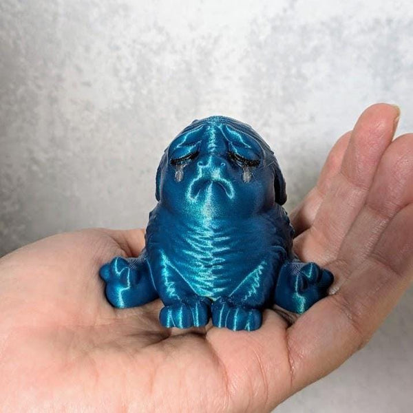 Metallic blue "cerulean sadness" Squonk figurine held in a hand, tragically beautiful and filled with unspeakable sorrow.