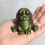 Swamp Grief Green Squonk in a hand, eyes closed in anguish, forever mourning its reflection and regretting 2007.