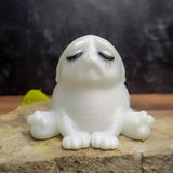 A Moonstone Tears squonk, glowing in ethereal sadness while sitting on a rock.