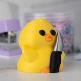 Yellow duck holding a knife with a blurred background