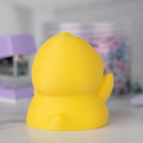 Back view of a yellow duck on a blurred background