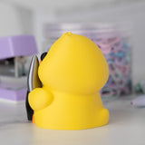 Side view of a yellow duck with a knife on a blurred background