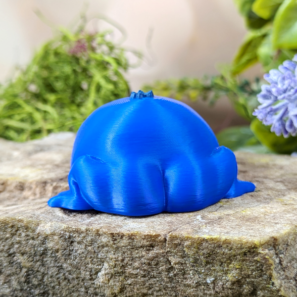 Rear view of Blueberry Frog figurine highlighting its smooth, rounded back and frog legs.